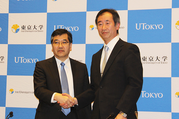 2015.10.06 Professor Kajita shaking hands with University of Tokyo President Makoto Gonokami at the press conference