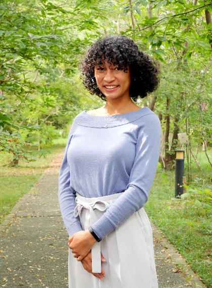 Student standing in a green area outdoors