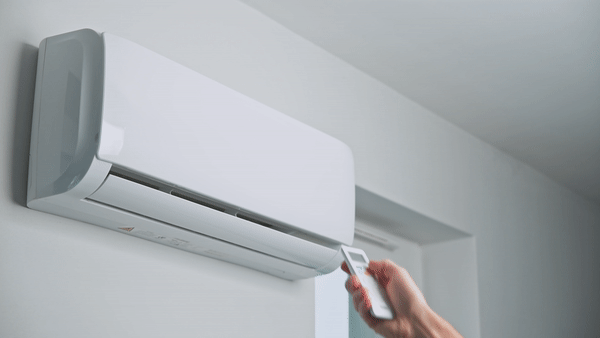 Gif of a hand turning on a room air conditioner using a controller. 