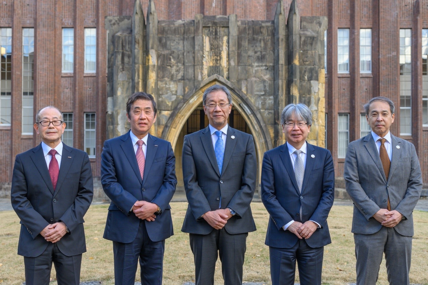 安田講堂前で記念撮影に納まる藤森専務執行役員、片山会長CEO、藤井総長、加藤研究科長、高橋教授